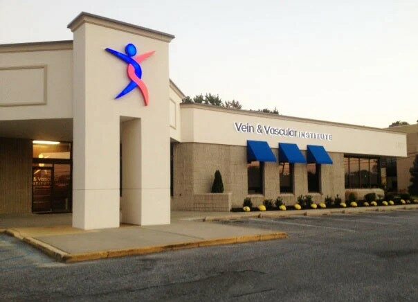 tan building with blue and red logo that reads vein and vascular institute