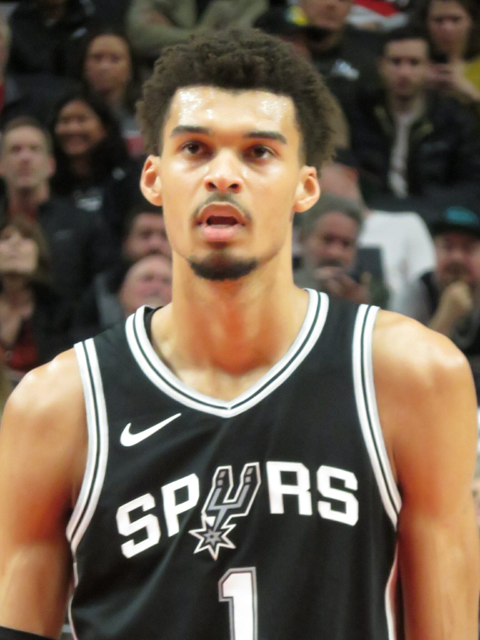 Victor Wembanyama of the San Antonio Spurs standing on the court during an NBA game in 2024.
