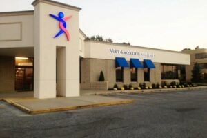 tan building with blue and red logo that reads vein and vascular institute