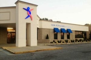 tan building with blue and red logo that reads vein and vascular institute